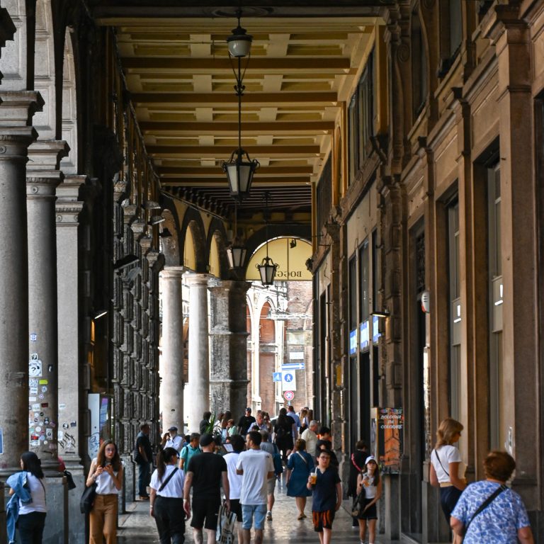 Image3 Locals and tourists alike walking through the porticos in Bologna, Italy